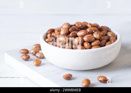 Fagioli romani secchi non cotti nel recipiente o cucchiaio sul tavolo, concetto di fagioli leguminosi Foto Stock