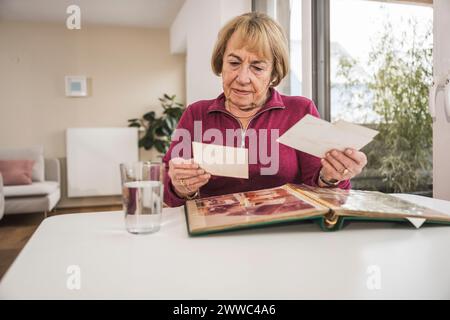 Senior donna guardando le fotografie Foto Stock