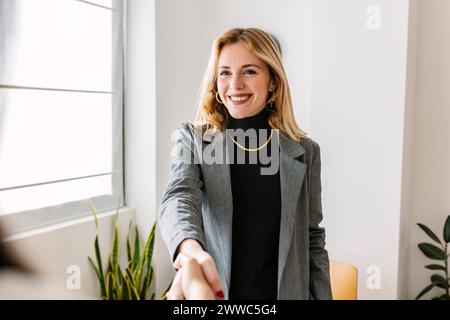 Reclutatore sorridente che stringe la mano al candidato Foto Stock