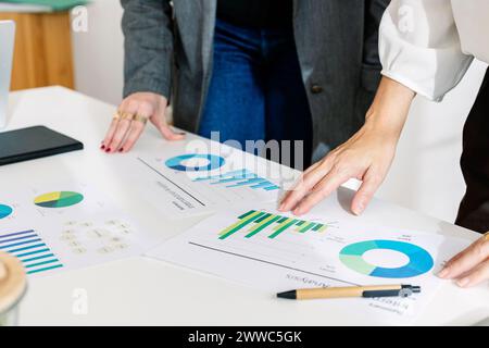 Donna d'affari che discute di grafici e grafici con un collega in carica Foto Stock