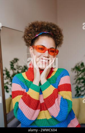 Donna felice che indossa occhiali da sole di colore arancione Foto Stock