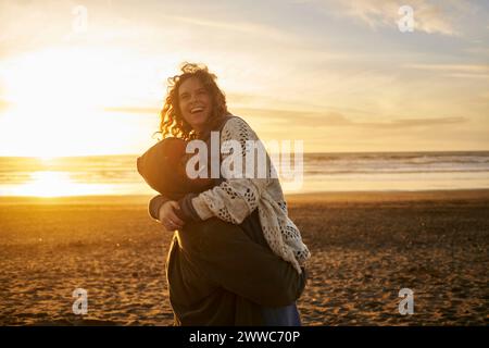 Felice coppia giovane per divertirsi in spiaggia Foto Stock