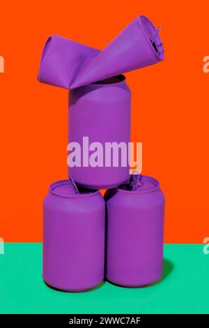 Lattine viola impilate su uno sfondo dai colori vivaci Foto Stock