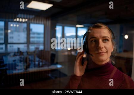 Venditore che parla con il cliente tramite la cuffia in ufficio Foto Stock