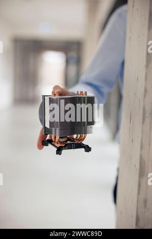 Mano del tecnico che tiene la parte della macchina in officina Foto Stock