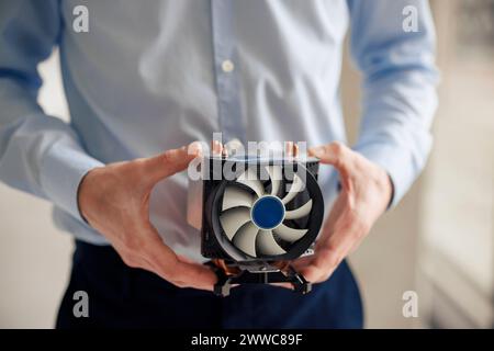 Ingegnere maturo che tiene la ventola della CPU in officina Foto Stock