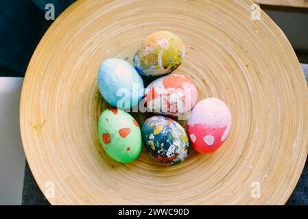 Uova di Pasqua multicolore nel piatto a casa Foto Stock