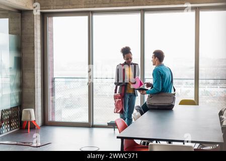 Giovani colleghi di lavoro che discutono sul posto di lavoro Foto Stock