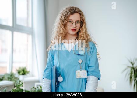 Medico che indossa scrub e si trova in clinica Foto Stock