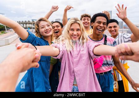 Giovani amici felici che si tengono per mano e si divertono insieme Foto Stock