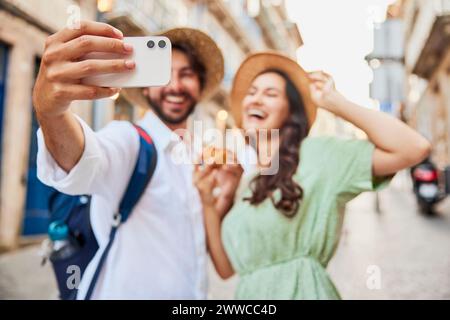 Felice giovane coppia che prende selfie attraverso lo smartphone Foto Stock