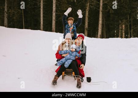 Famiglia felice che si diverte nella foresta invernale Foto Stock
