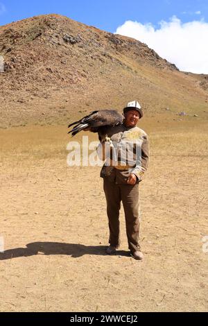 27 2023 agosto - Bokonbayevo, provincia di Issyk Kul in Kirghizistan: Un cacciatore di aquile del Kirghizistan con la sua aquila Foto Stock