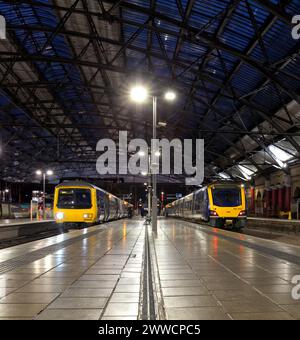 Treno elettrico a più unità Northern Rail classe 331 (destra) e classe 323 (sinistra) sotto il tetto alla stazione ferroviaria di Liverpool Lime Street di notte Foto Stock