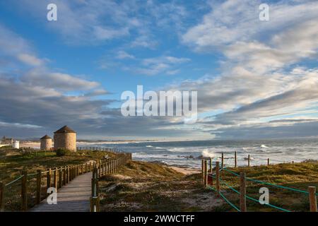 Bellissimo paesaggio di antichi mulini a vento tradizionali sul sentiero costiero della spiaggia di Puglia in Portogallo Foto Stock