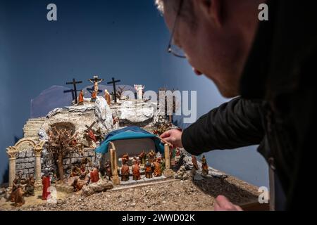 Bamberga, Germania. 23 marzo 2024. Michael Suffa di The Bamberg Nativity Friends dà il tocco finale a un Presepe della passione. Dal 23 marzo al 7 aprile 2024, oltre 30 presepi raffiguranti la passione, la morte e la risurrezione di Cristo saranno esposti nella Maternkapelle Bamberga. Mentre l'allestimento di presepi a Natale è ancora oggi un'usanza popolare, i presepi della passione sono raramente visti. Crediti: Pia Bayer/dpa/Alamy Live News Foto Stock