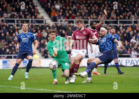 Sonny Bradley (a destra) del Derby County ha il suo tiro salvato dal portiere del Northampton Town Louie Moulden durante la partita Sky Bet League One al Sixfields Stadium di Northampton. Data foto: Sabato 23 marzo 2024. Foto Stock