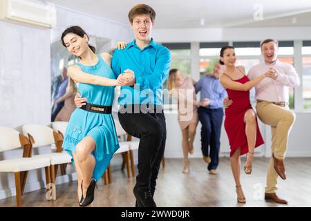 Allegra giovane coppia che ballano giocoso jitterbug in studio di danza Foto Stock