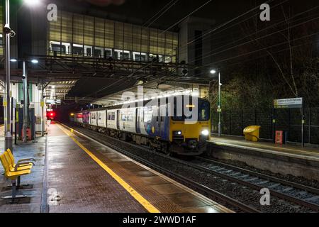 2 treni diesel a più unità di classe 150 Northern Rail che fanno scalo alla stazione ferroviaria di Liverpool South Parkway di notte Foto Stock