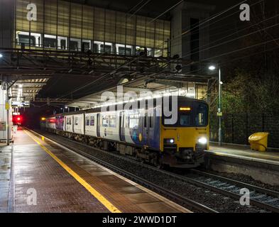 2 treni diesel a più unità di classe 150 Northern Rail che fanno scalo alla stazione ferroviaria di Liverpool South Parkway di notte Foto Stock