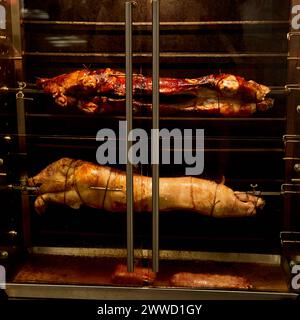 Arrostire Suckling Pigs on Spit in un mercato parigino Foto Stock