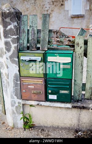 Cassette postali verdi e marroni impostate in Broken Old Fence Foto Stock