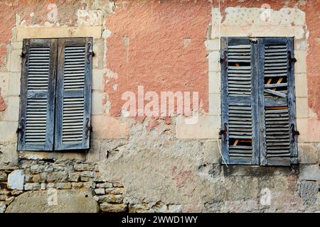 Broken Blue Shutters in un edificio arancione Foto Stock