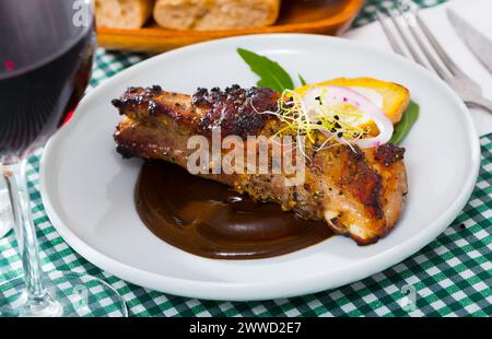 Costolette di maiale arrosto in salsa al cioccolato con patate al forno Foto Stock