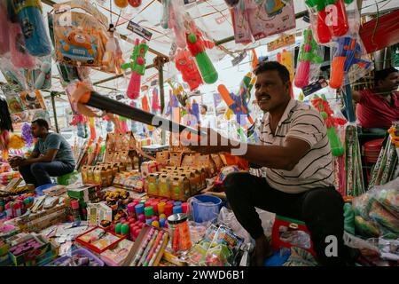 Guwahati, Assam, India. 23 marzo 2024. Il venditore vende articoli per festeggiare Holi in un mercato di strada, in vista del festival Holi il 23 marzo 2024 a Guwahati, Assam, India. Holi è la festa indù dei colori, è celebrata con grande gioia in India. Crediti: David Talukdar/Alamy Live News crediti: David Talukdar/Alamy Live News Foto Stock