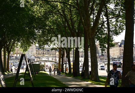 Versailles, Parigi, Francia, 30 giugno 2022. Persone all'ombra del viale alberato che conduce alla magnifica porta d'oro del palazzo reale. Il Foto Stock