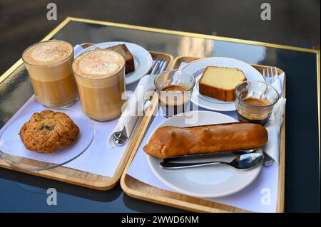 Parigi, Francia. Una ricca colazione con dolci tipici e cappuccino e caffè. Vista di tre quarti. Foto Stock