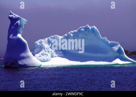 Grande iceberg vicino alla riva su un mare calmo sotto all'inizio dell'estate Foto Stock