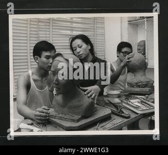 Vivian Sun fornisce indicazioni al suo assistente tirocinante presso la Little House of Wax di Hong Kong nel 1969, dimostrando le tecniche di modellazione della cera. Foto Stock