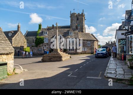 The Square, Corfe Castle, UK - 14 settembre 2023: La piazza del villaggio con la croce che commemora il Giubileo di Diamante della Regina Vittoria nel 1897, e il Foto Stock