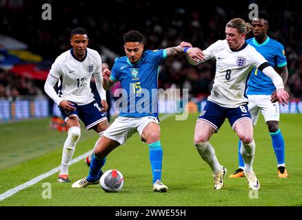 Il brasiliano Joao Gomes combatte per la palla con l'inglese Conor Gallagher (a destra) ed Ezri Konsa durante un'amichevole internazionale allo stadio di Wembley, Londra. Data foto: Sabato 23 marzo 2024. Foto Stock