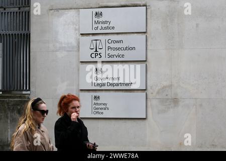 Le donne passano le indicazioni fuori 102 Petty France a Westminster, nel centro di Londra. Gli uffici del Ministero della giustizia, del Crown Prosecution Service, del Dipartimento legale del governo e dell'Ufficio del Procuratore generale si trovano nell'edificio 102 di Petty France. Foto Stock