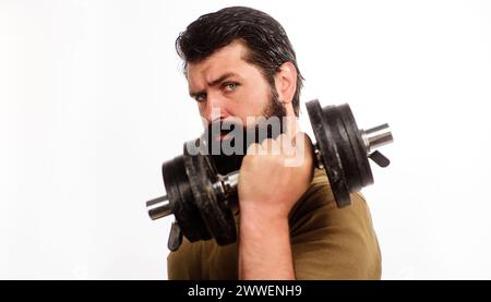 Un uomo serio con il manubrio in mano. Portabagagli per il sollevamento di manubri in un club sportivo. Culturista forte e attraente in allenamento nella palestra fitness. Peso Foto Stock