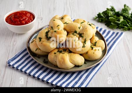Nodi di aglio fatti in casa con prezzemolo su piatto, vista laterale. Foto Stock