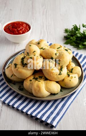 Nodi di aglio fatti in casa con prezzemolo su piatto, vista laterale. Foto Stock