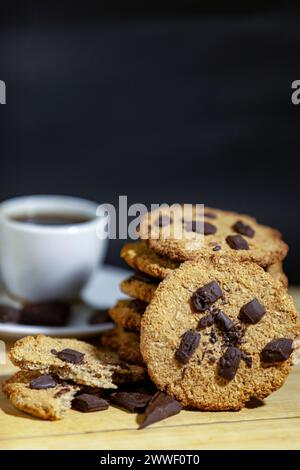 Biscotti con farinata d'avena. Biscotti d'avena fatti a mano per il caffè. Pasticceria fatta in casa con cioccolato su sfondo scuro. Copia spazio. Foto Stock