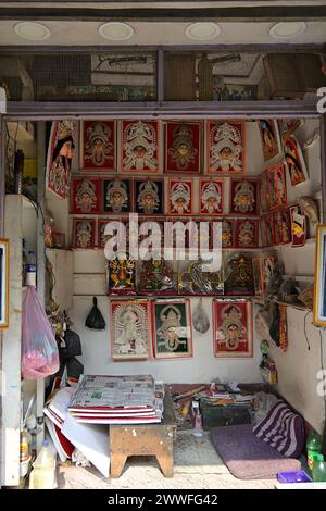 Immagini incorniciate della dea indù Durga in vendita presso lo stand di un artigiano a Kumartili, un vecchio quartiere di Kolkata, sede di una comunità di idol maker Foto Stock