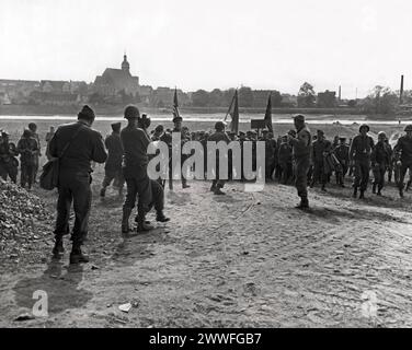 Torgau, Germania, 26 aprile 1945 i fotografi di guerra americani e russi coprono uno storico incontro ufficiale tra gli ufficiali della prima Armata americana e dell'Armata russa sulla riva orientale del fiume Elba a Torgau. Le bandiere dei tre maggiori alleati stanno volando sopra le teste dei funzionari. L'incontro ufficiale seguì il collegamento tra la prima Armata degli Stati Uniti e la pattuglia russa sul fiume Elba, ad est di Torgau. Foto Stock