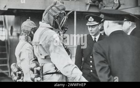 Una fotografia del 1944 cattura re Giorgio vi che incontra un equipaggio di "siluri umani", mostrato nel loro equipaggiamento da immersione. Questi equipaggi gestivano sottomarini in miniatura utilizzati in operazioni sotto copertura durante la seconda guerra mondiale, una testimonianza della loro audacia e innovazione nella guerra navale. La visita del re riconosce il loro ruolo cruciale, ma pericoloso, nel conflitto. Foto Stock