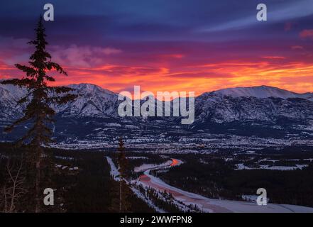 Vibrante cielo all'alba sulle montagne e sulla città di Canmore Foto Stock