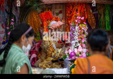 Chiang mai, Thailandia. 23 marzo 2024. Un giovane ragazzo etnico Shan vestito in costume colorato gioca con il suo giocattolo dopo una lunga processione annuale di Poy Sang, un tradizionale rito di passaggio per i ragazzi da avviare come novizi buddisti al Tempio di Wat Ku Tao. POY Sang Long è una cerimonia di ordinazione buddista da novizio, del popolo tribale Yai tailandese, ma a differenza di qualsiasi altra cerimonia del suo tipo nel paese. I ragazzi di età compresa tra i 7 e i 14 anni sono ordinati come novizi per imparare le dottrine buddiste. Credito: SOPA Images Limited/Alamy Live News Foto Stock