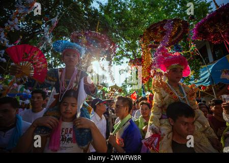 Giovani ragazzi etnici Shan vestiti con costumi colorati vengono portati sulle spalle dei loro familiari durante una lunga processione annuale di Poy Sang, un tradizionale rito di passaggio per i ragazzi da iniziare come novizi buddisti al Tempio di Wat Ku Tao. POY Sang Long è una cerimonia di ordinazione buddista da novizio, del popolo tribale Yai tailandese, ma a differenza di qualsiasi altra cerimonia del suo tipo nel paese. I ragazzi di età compresa tra i 7 e i 14 anni sono ordinati come novizi per imparare le dottrine buddiste. (Foto di Pongmanat Tasiri/SOPA Images/Sipa USA) Foto Stock