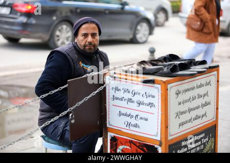 Gaziantep, Turkiye. 22 marzo 2024. Gaziantep, Turkiye. 22 marzo 2024. Uno shiner per scarpe accanto al carrello da lavoro per le strade della città turca di Gaziantep. La lucidatura delle scarpe è un commercio secolare molto vivo a Turkiye, dove è considerata una professione rispettosa. In Turchia, infatti, i lucidatrici sono una parte essenziale della vita quotidiana, con la gente del posto che apprezza l'arte e le abilità dei lucidatrici di scarpe professionali ed esperti (Credit Image: © Zakariya Yayha/IMAGESLIVE via ZUMA Press Wire) SOLO PER USO EDITORIALE! Non per USO commerciale! Foto Stock