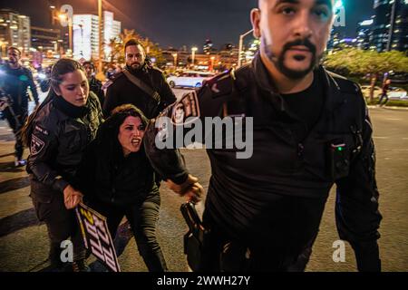 Tel Aviv, Israele. 23 marzo 2024. Noam Dan, un membro della famiglia dell'ostaggio israeliano Ofer Kalderon, trascinato da agenti di polizia durante un blocco stradale. Migliaia di manifestanti contro il primo ministro Benjamin Netanyahu si sono Uniti alle famiglie israeliane degli ostaggi chiedendo un accordo immediato con gli ostaggi, un cessate il fuoco e elezioni generali nello Stato di Israele. Gli scontri con la polizia israeliana si sono verificati dopo che i manifestanti avevano incendiato alcuni falò di fronte al quartier generale dell'IDF e sull'autostrada Ayalon, 15 sono stati arrestati. Credito: SOPA Images Limited/Alamy Live News Foto Stock