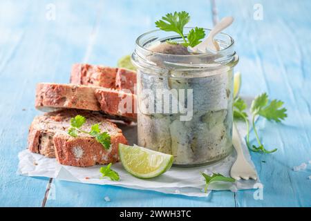 Aringhe fresche e deliziose marinate come fonte di grasso omega. Pesce in vaso servito con pane. Foto Stock