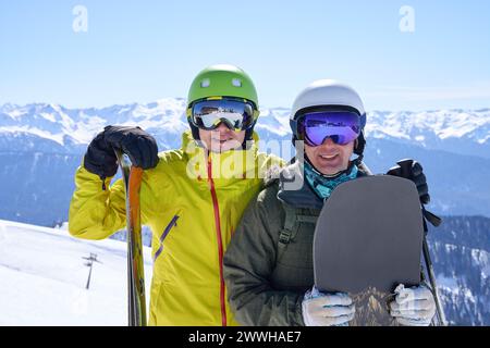 Due uomini felici con caschi da sci e snowboard, che amano gli sport invernali. Foto Stock